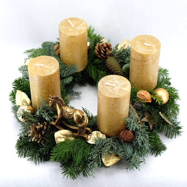 Strahlender Adventskranz in Gold mit Schaukelpferd